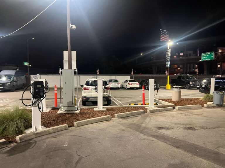 Electrician performing final wiring or inspection on an EV charging unit.